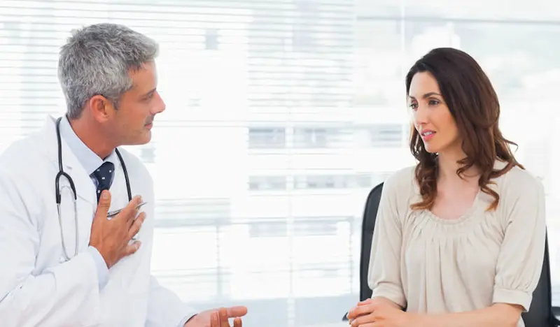Médico explicando a paciente la diferencia entre tumor maligno y benigno