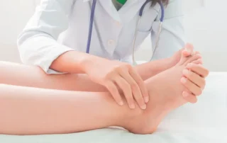 medica revisando a un paciente con los pies hinchados