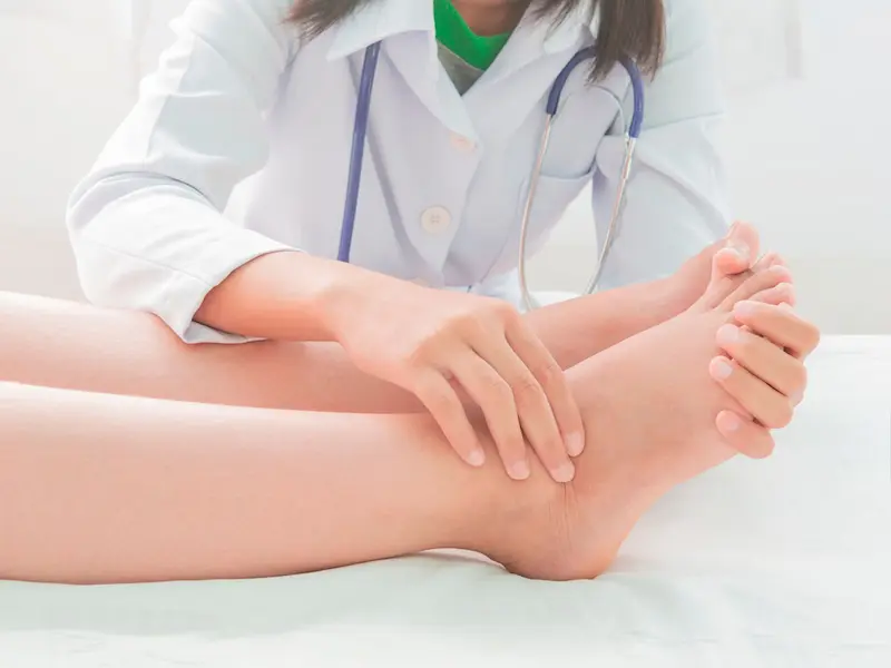 medica revisando a un paciente con los pies hinchados