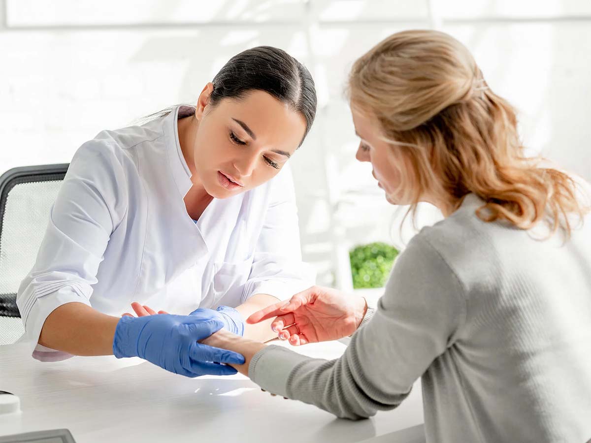 Médico tratando a una paciente con psoriasis