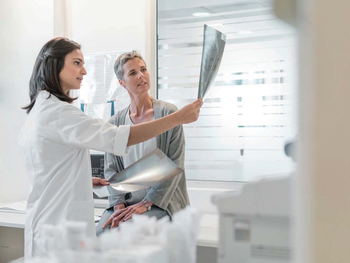 Médico y paciente hablando de beneficios del diagnóstico por imagen