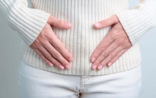 Persona con manos en el abdomen por perimenopausia