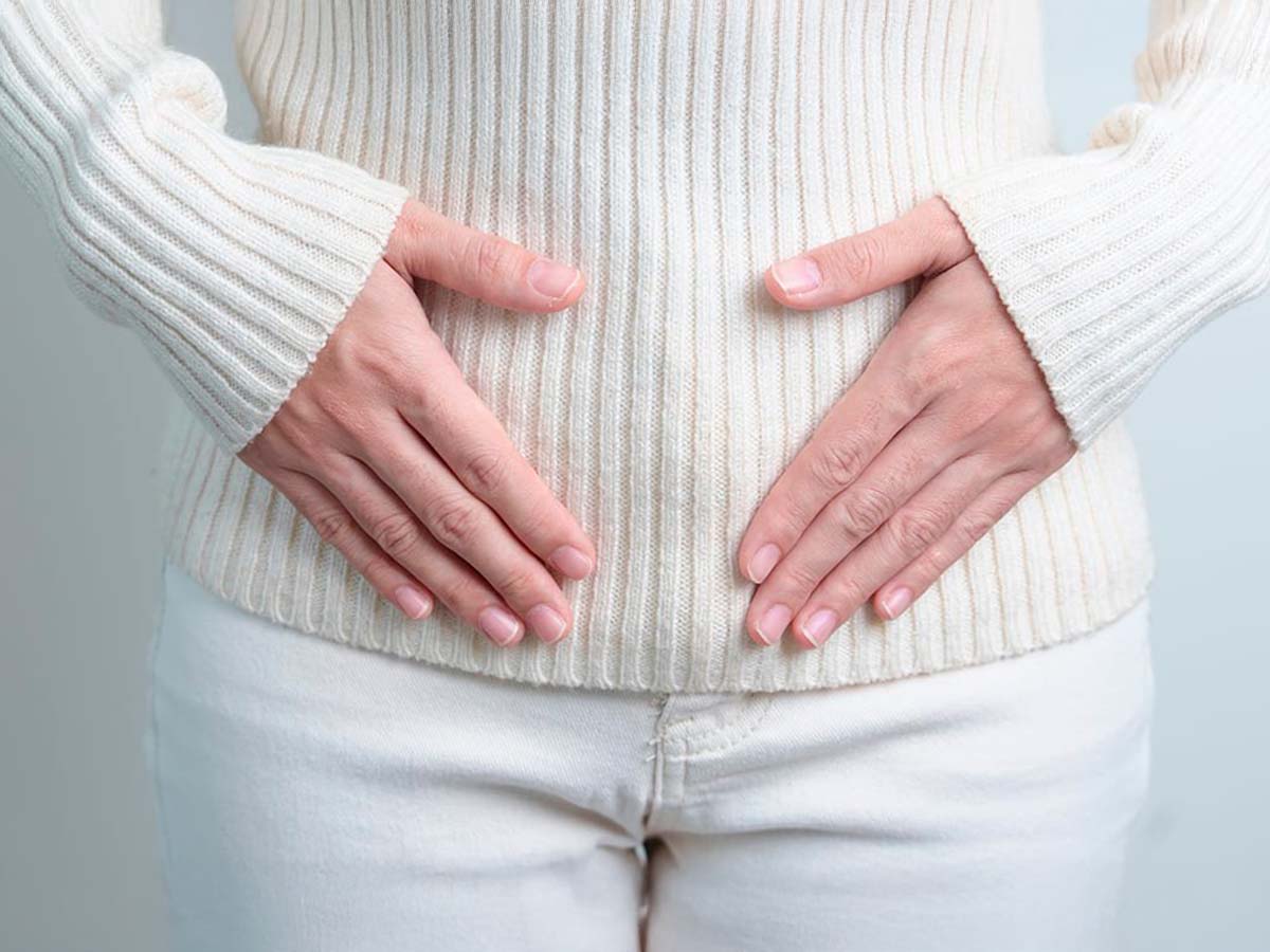 Persona con manos en el abdomen por perimenopausia