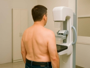 Paciente haciéndose una mamografia masculina