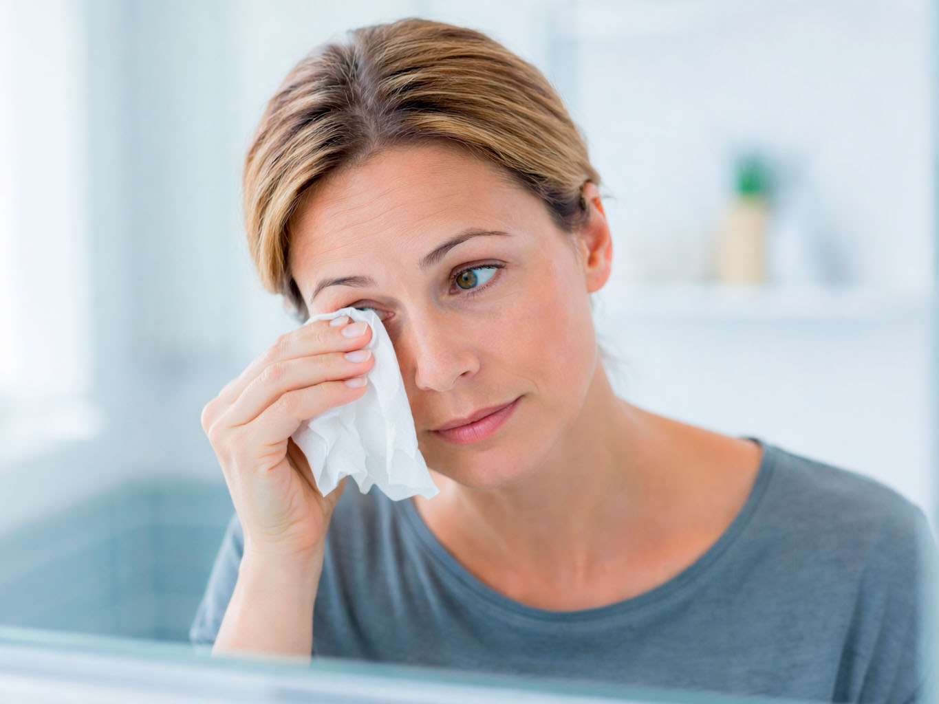 mujer limpiando su ojo lloroso constante