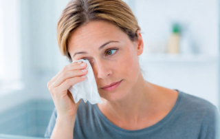 mujer limpiando su ojo lloroso constante